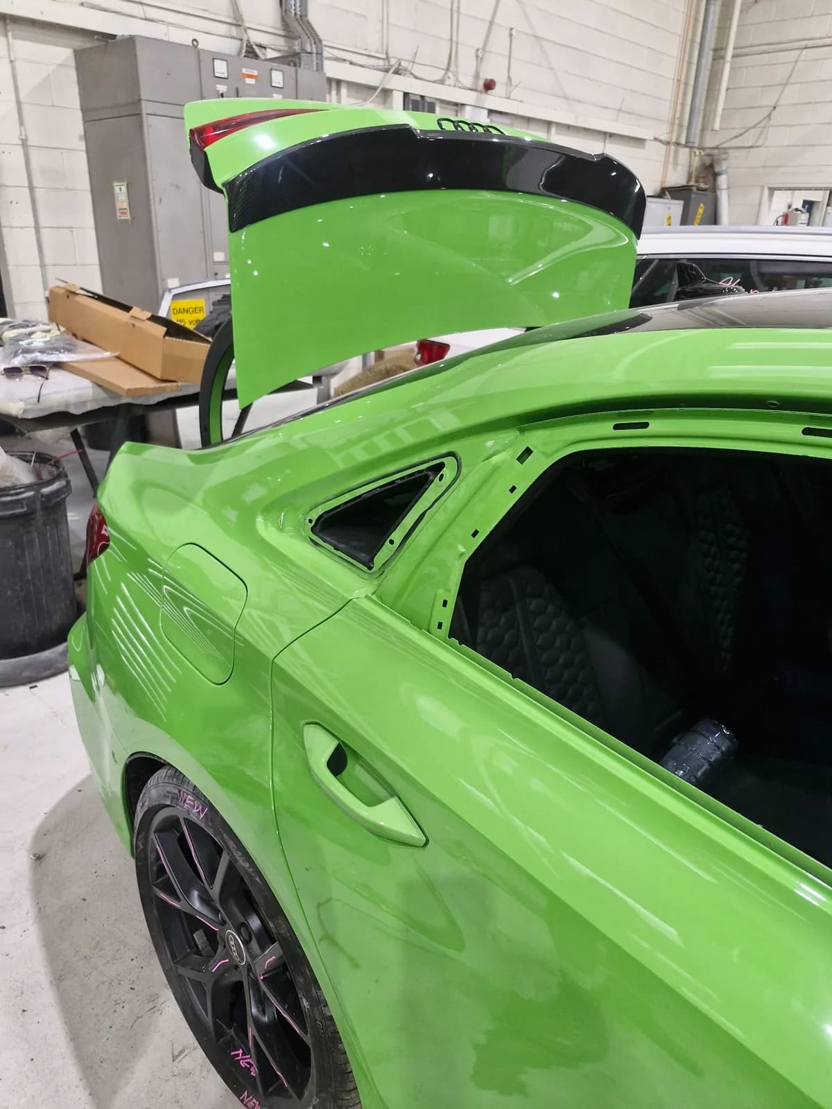 Rear quarter glass aperture exposed on a green Audi.