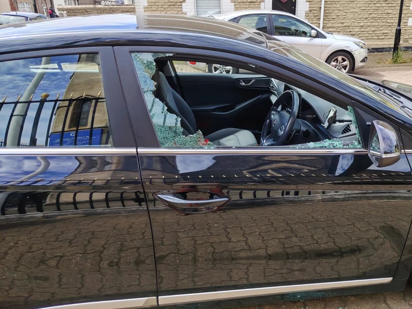 Shattered front side-door window on a black Hyundai.
