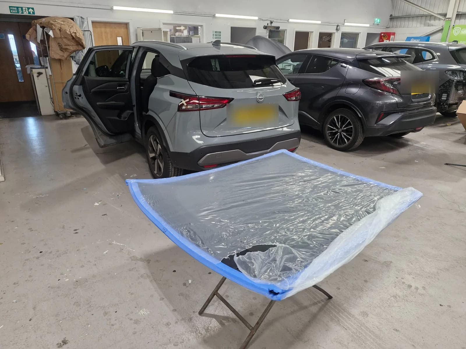 Replacement windscreen prepared in a bodyshop workshop.