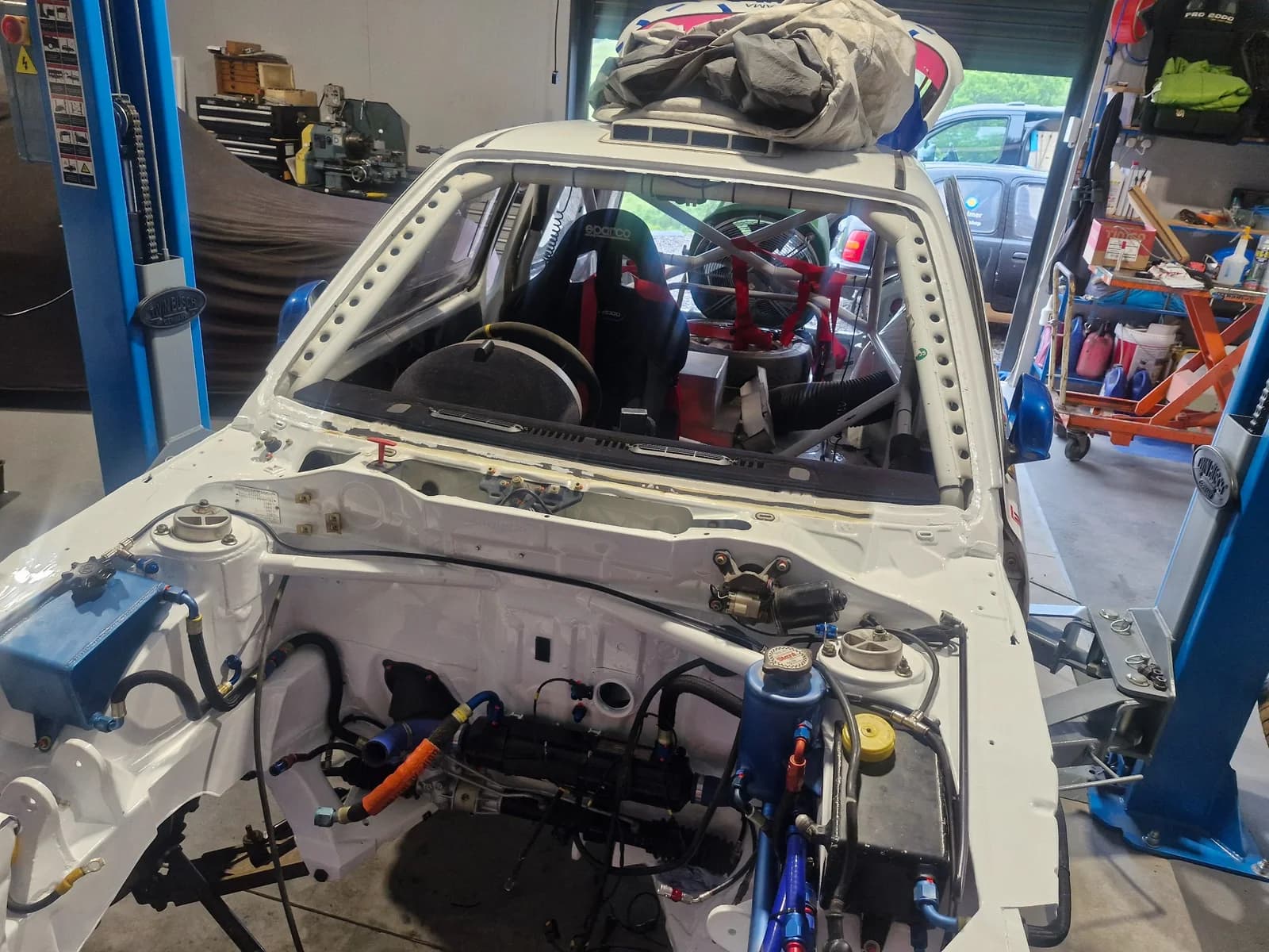 Specialist vehicle with its windscreen removed, showing the exposed front aperture in the workshop.