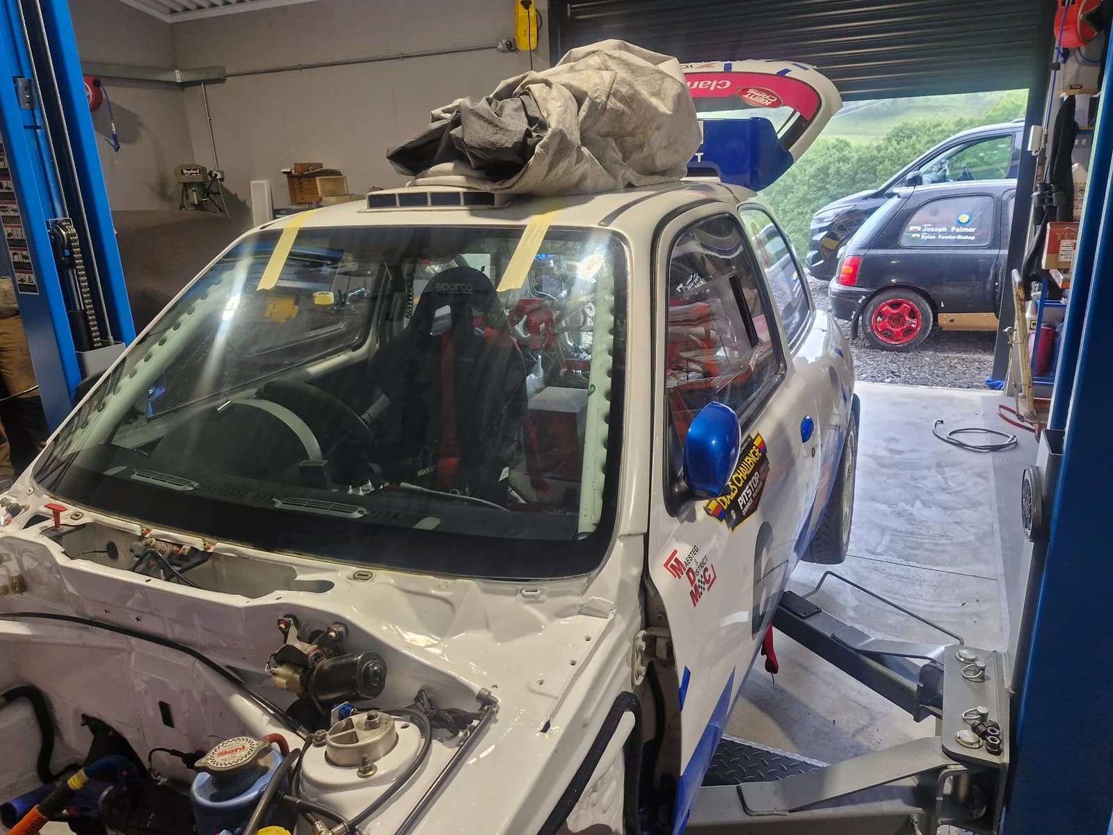 Specialist competition vehicle inside a working vehicle workshop.